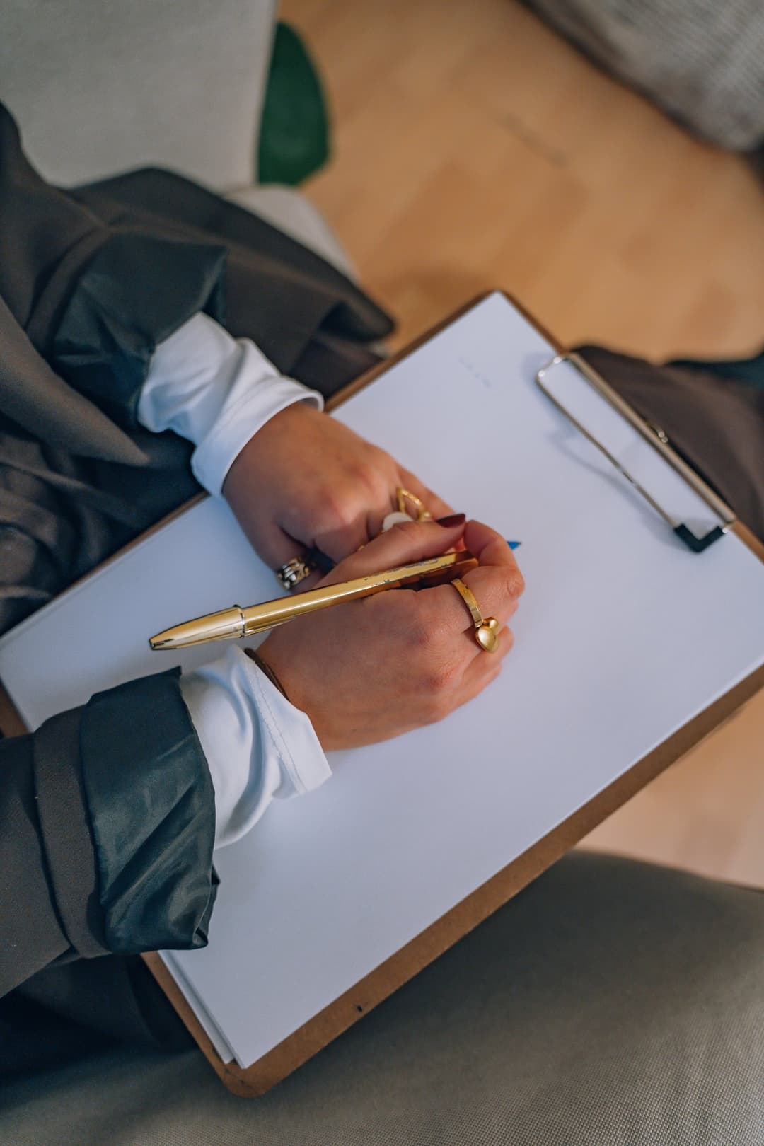 Detalle de manos escribiendo en clipboard